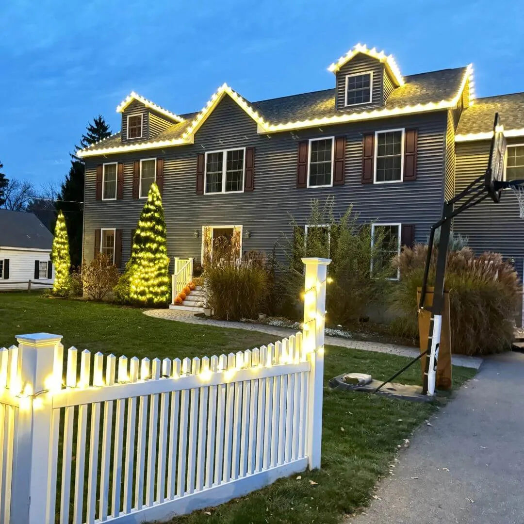 Residential holiday lighting installation — warm white roofline and entryway lights